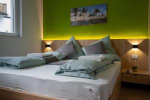 a bedroom with a large bed with green walls at Luani appartments in Krefeld