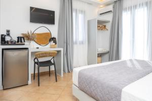 a bedroom with a bed and a desk with a chair at Olive Garden Hotel in Agios Prokopios