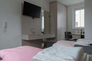 a bedroom with two beds and a tv on the wall at Luani appartments in Krefeld