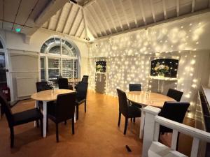 a dining room with two tables and chairs and lights at The Wrey Arms in Barnstaple