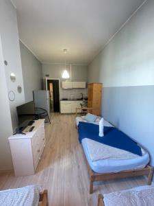 a room with a blue bed and a kitchen at FRESCO PLUS -Filharmonia in Łódź