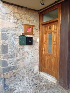 a wooden door on a stone building with a stone wall at Casona MilaWen in Potes