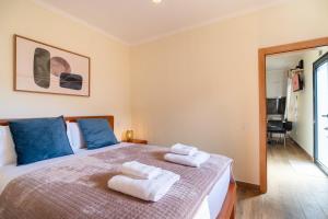 a bedroom with a bed with towels on it at GuestReady - Casa do Feno in Santa Cruz