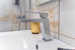 a silver sink in a bathroom with a mirror at GuestReady - Casa do Feno in Santa Cruz