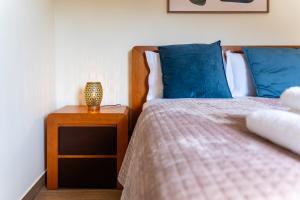 a bedroom with a bed with blue pillows and a night stand at GuestReady - Casa do Feno in Santa Cruz +30 photos