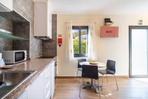 a kitchen with a table and chairs and a window at GuestReady - Casa do Feno in Santa Cruz