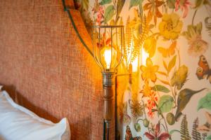 a lamp on the side of a wall with flowers at Marrian George Hotel in Koringberg