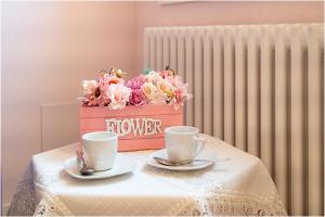 a box of flowers sitting on a table with two cups at Tiffany Home in Burano
