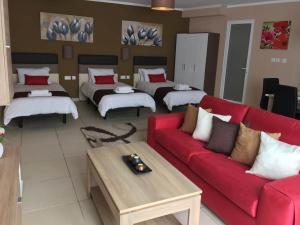 a living room with a red couch and beds at Belle Apartments in St. Julianʼs +31 photos