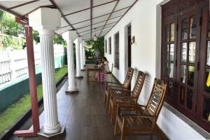 a row of chairs sitting on the porch of a house at Upali Homestay in Kandy