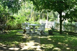 a picnic table and chairs in a yard with a fence at Upali Homestay in Kandy +1 photo