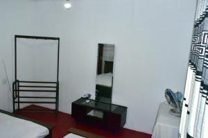 a living room with a mirror and a bed at Upali Homestay in Kandy