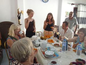 a group of people sitting around a table eating food at Upali Homestay in Kandy
