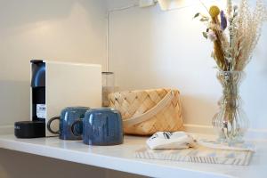 a counter with two blue mugs and a vase at Klippen Hotel - Therns in Gudhjem