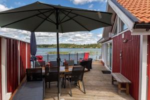 a patio with a table and chairs and an umbrella at OGO827-Vreta-Kloster-Sjoebacka-17 in Vreta Kloster