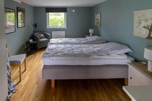 a bedroom with a large bed and a chair at OGO827-Vreta-Kloster-Sjoebacka-17 in Vreta Kloster
