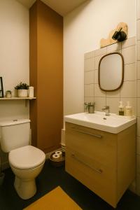 a bathroom with a toilet and a sink with a mirror at Charmant studio cosy - hypercentre Capitole in Toulouse