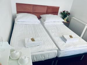 two beds in a room with a table and towels at K&B Residence in Jarosław