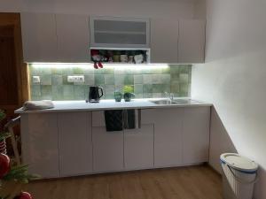 a kitchen with white cabinets and a sink at Apartmán Monarchia in Banská Štiavnica