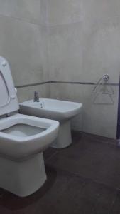 a bathroom with a white toilet and a sink at paraíso lomas in San Antonio de Arredondo +9 photos