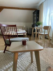 a living room with a coffee table and a chair at Apartmán Monarchia in Banská Štiavnica