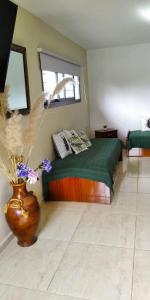 a bedroom with a bed and a vase with flowers at paraíso lomas in San Antonio de Arredondo
