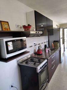 a kitchen with a stove and a microwave at paraíso lomas in San Antonio de Arredondo
