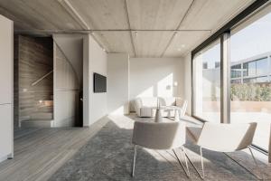 a dining room with white chairs and a table at Coliving - Bord de Meuse - L'instant in Oupeye