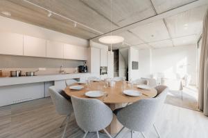 a dining room with a wooden table and chairs at Coliving - Bord de Meuse - L'instant in Oupeye