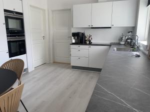 a kitchen with white cabinets and a table and chairs at Private apartment with panoramic ocean views in Ilulissat