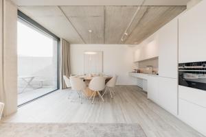 a kitchen and dining room with a table and chairs at Coliving - Bord de Meuse - L'instant in Oupeye +41 photos