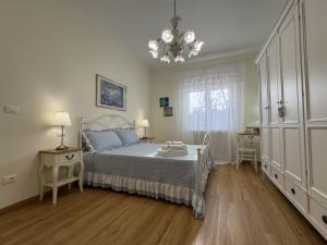a bedroom with a bed and a chandelier at Le Jardin Fleuri in Castelluccio Valmaggiore
