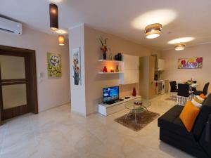 a living room with a black couch and a television at Belle Apartments in St. Julianʼs