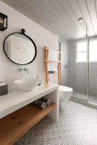 a bathroom with a sink and a mirror and a tub at Keresbino Hydra Port House in Hydra +7 photos