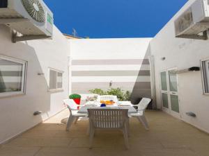 a patio with a table and chairs on a balcony at Belle Apartments in St. Julianʼs