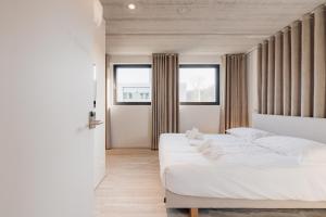 a bedroom with two beds and two windows at Coliving - Bord de Meuse - L'instant in Oupeye