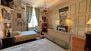 a bedroom with two beds and a chandelier at Château de la Chabroulie in Isle