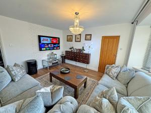 a living room with two couches and a tv at The Annexe in Peacehaven
