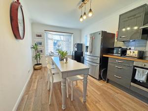 a kitchen with a table and a kitchen with a refrigerator at The Annexe in Peacehaven