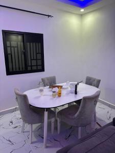 a white table with chairs in a room at JJ home in Amdalai
