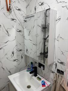 a white bathroom with a sink and a mirror at JJ home in Amdalai