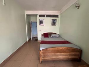 a bedroom with a bed in the corner of a room at The Parijat Inn in Mirik