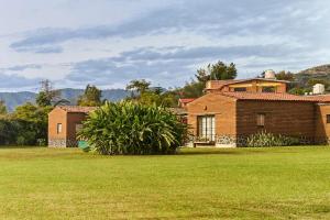 a brick house in a field of green grass at Casa Estrella, Mountain View in Malinalco