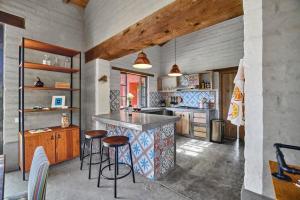 a kitchen with a counter and stools in a room at Casa Estrella, Mountain View in Malinalco