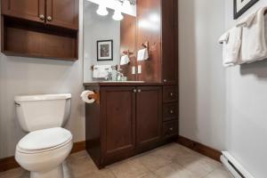 a bathroom with a white toilet and a sink at Cap Tremblant in Mont-Tremblant +24 photos
