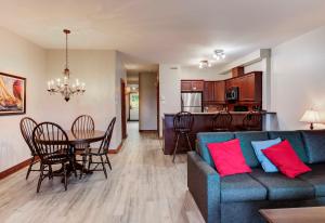 a living room and kitchen with a blue couch and a table at Cap Tremblant in Mont-Tremblant