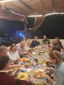 a group of people sitting around a long table eating food at Labib Guest house in Aswan +41 photos