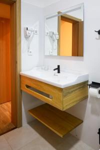 a bathroom with a sink and a mirror at GUMBELA - Hotel in São Tomé