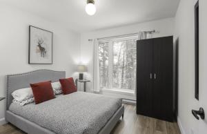 a bedroom with a bed and a large window at NatureX Spa River Dogfriendly in Sainte Béatrix