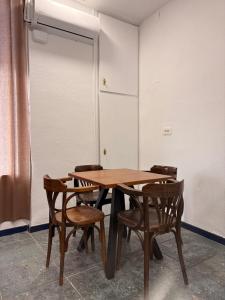 a wooden table and chairs in a room at LITTLE Hostel in Puerto de Sagunto